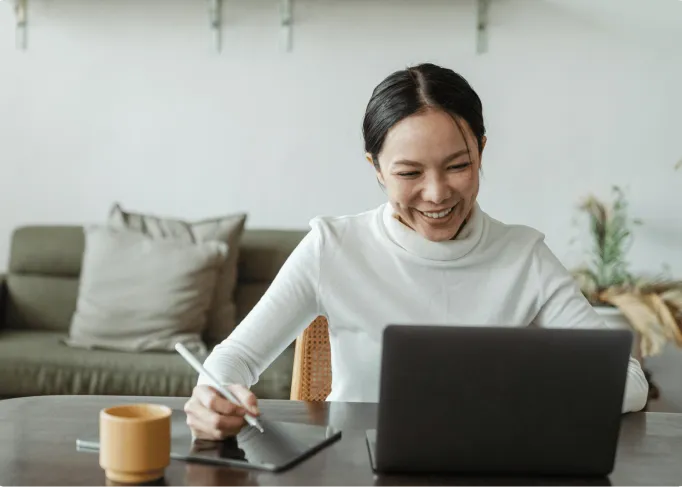 Caregiver manager using home care software to manage client schedules on a laptop and tablet.