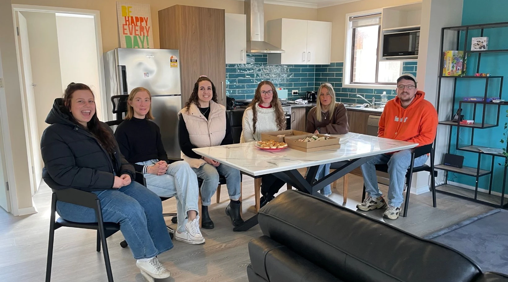 NDIS support team enjoying a casual lunch gathering inside a shared living home for disability services.
