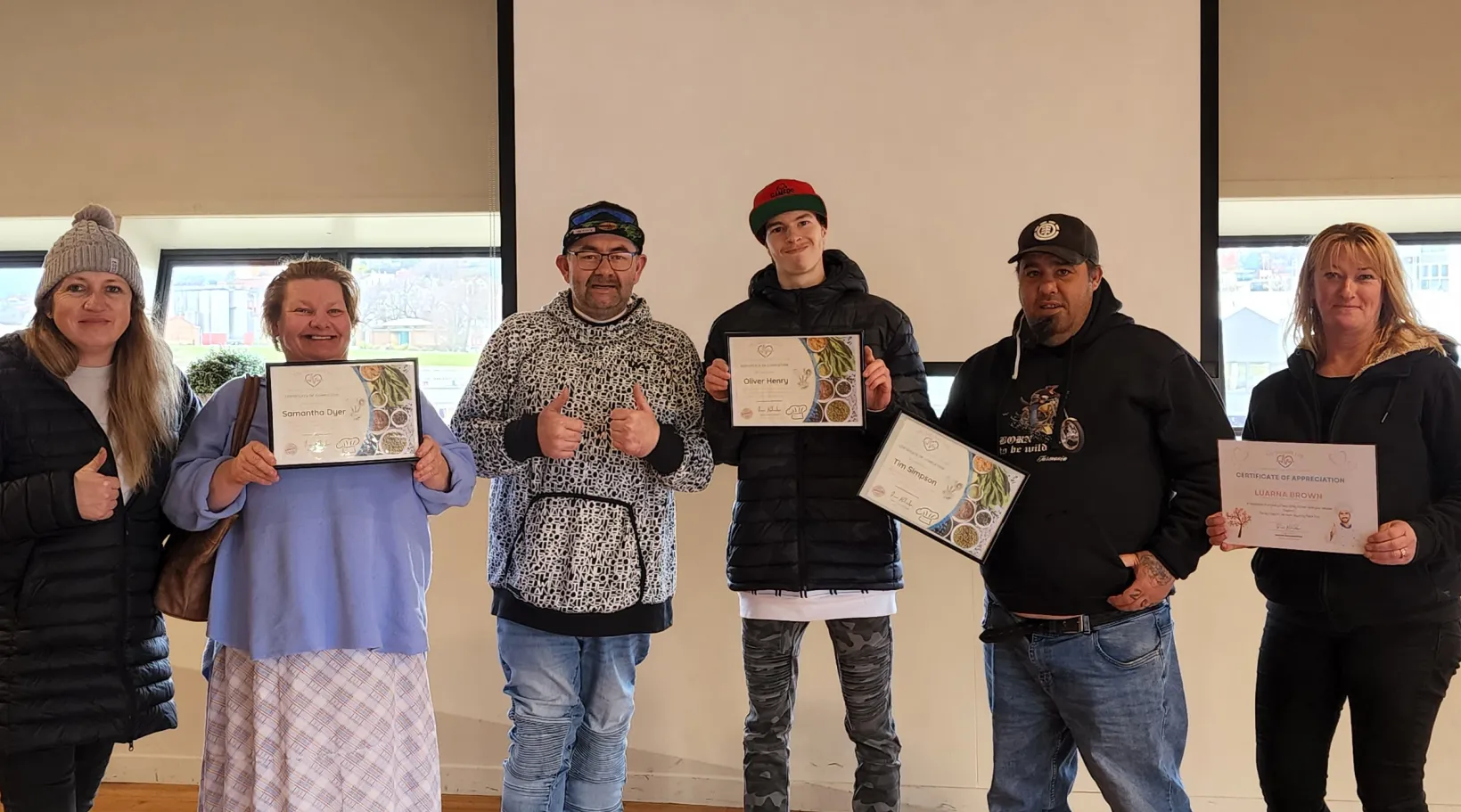 ShiftCare awardees standing together holding framed certificates.