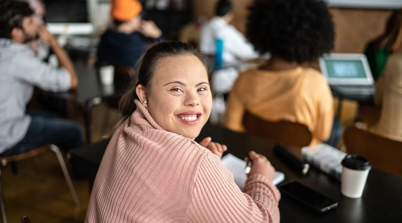 Confident student with Down syndrome attending supported education session.