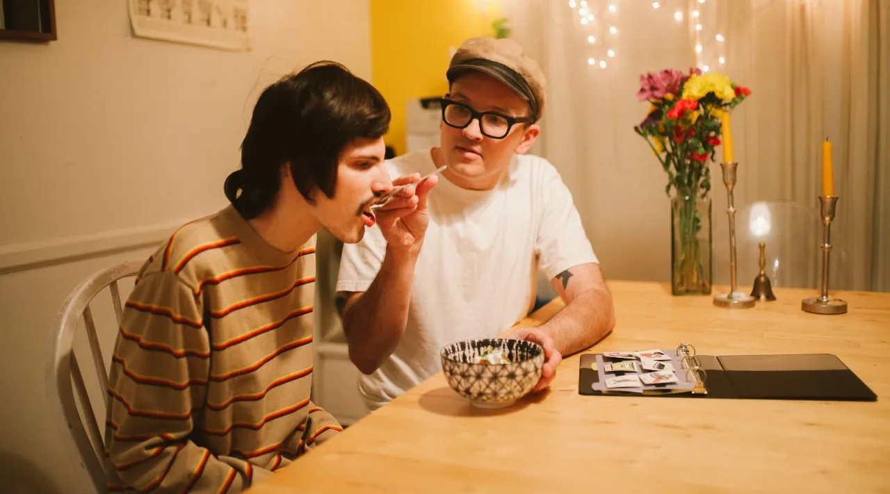 Caregiver helping client eat dinner at home, ShiftCare.