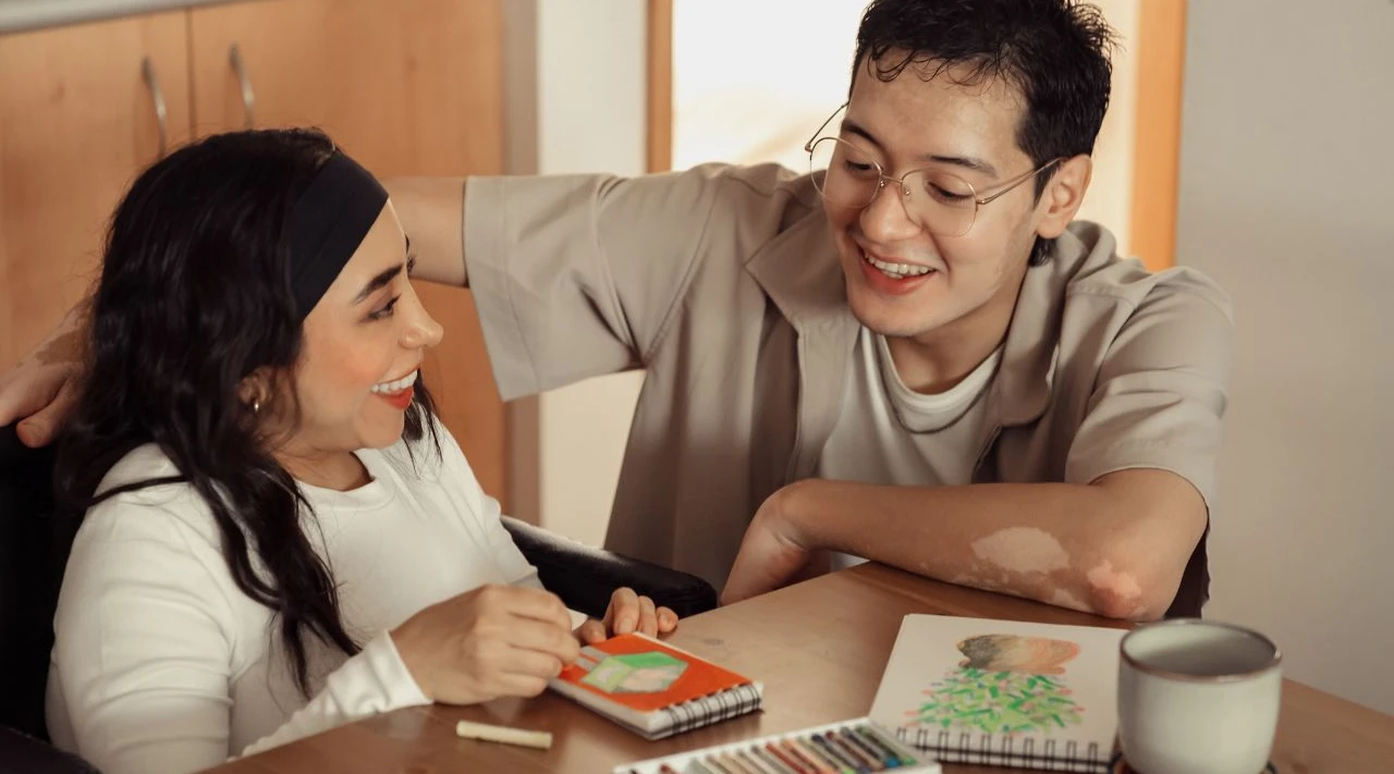 ShiftCare carer assisting client with creative therapy, strengthening confidence and communication.
