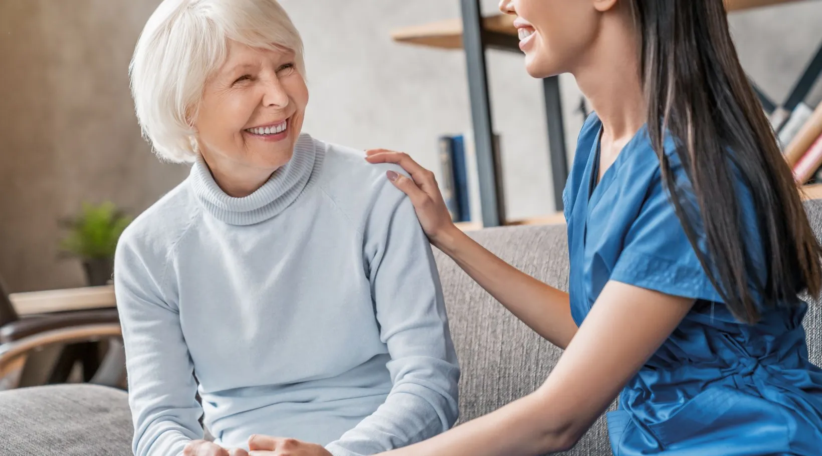 Caregiver providing compassionate home support to an elderly woman using ShiftCare software.