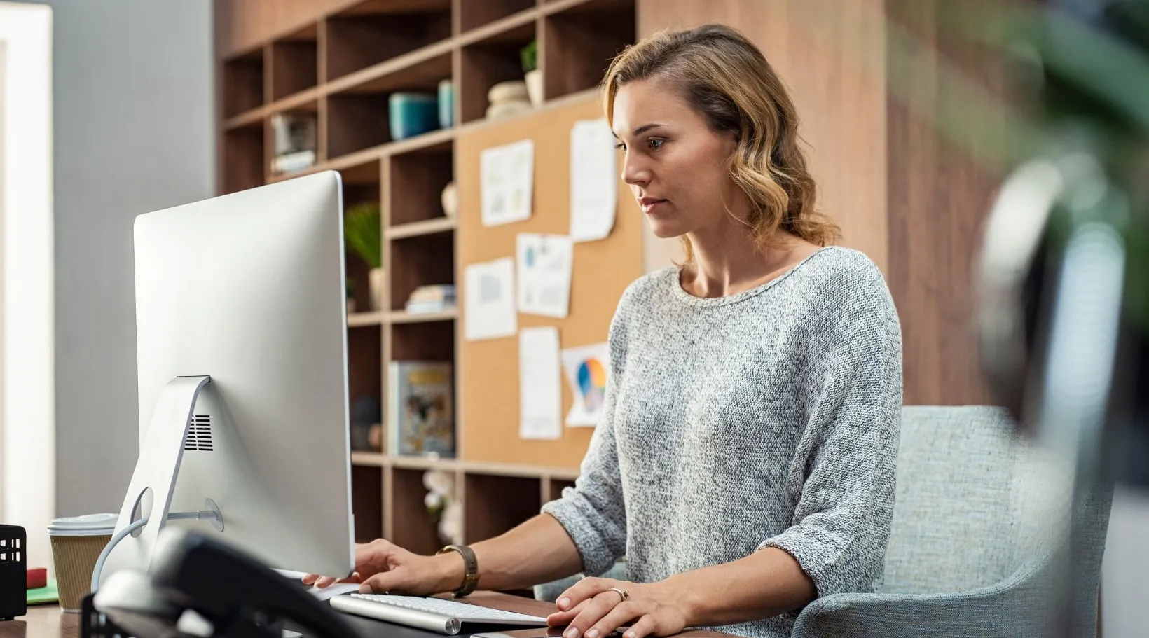 Woman using ShiftCare software on desktop to manage client schedules.