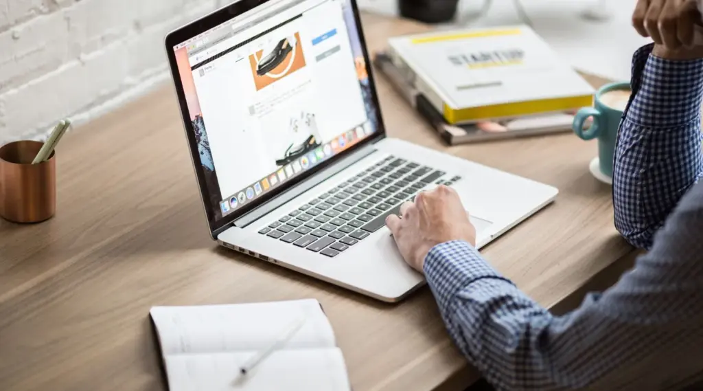 Professional working on laptop in office workspace, ShiftCare.