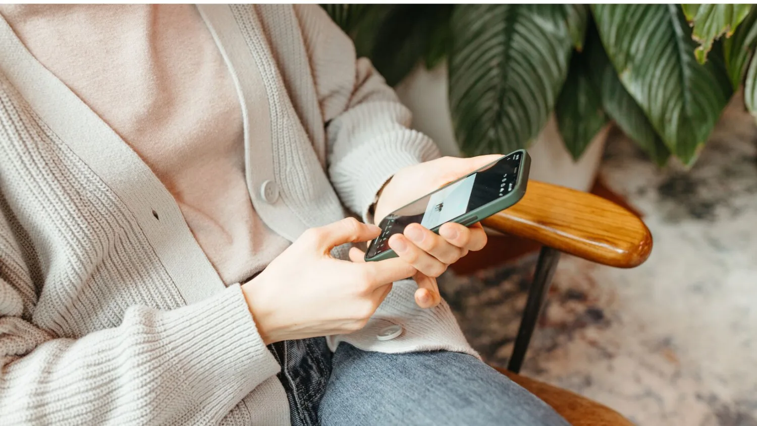 Team member checks roster and client messages on ShiftCare app, sitting comfortably.