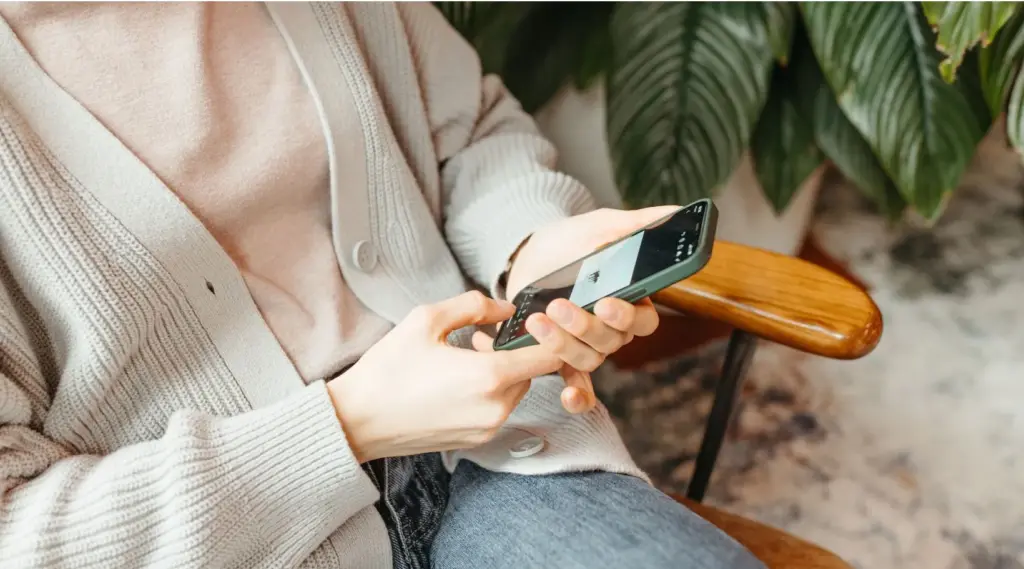 Care coordinator using the ShiftCare app on mobile to manage client updates and schedules.