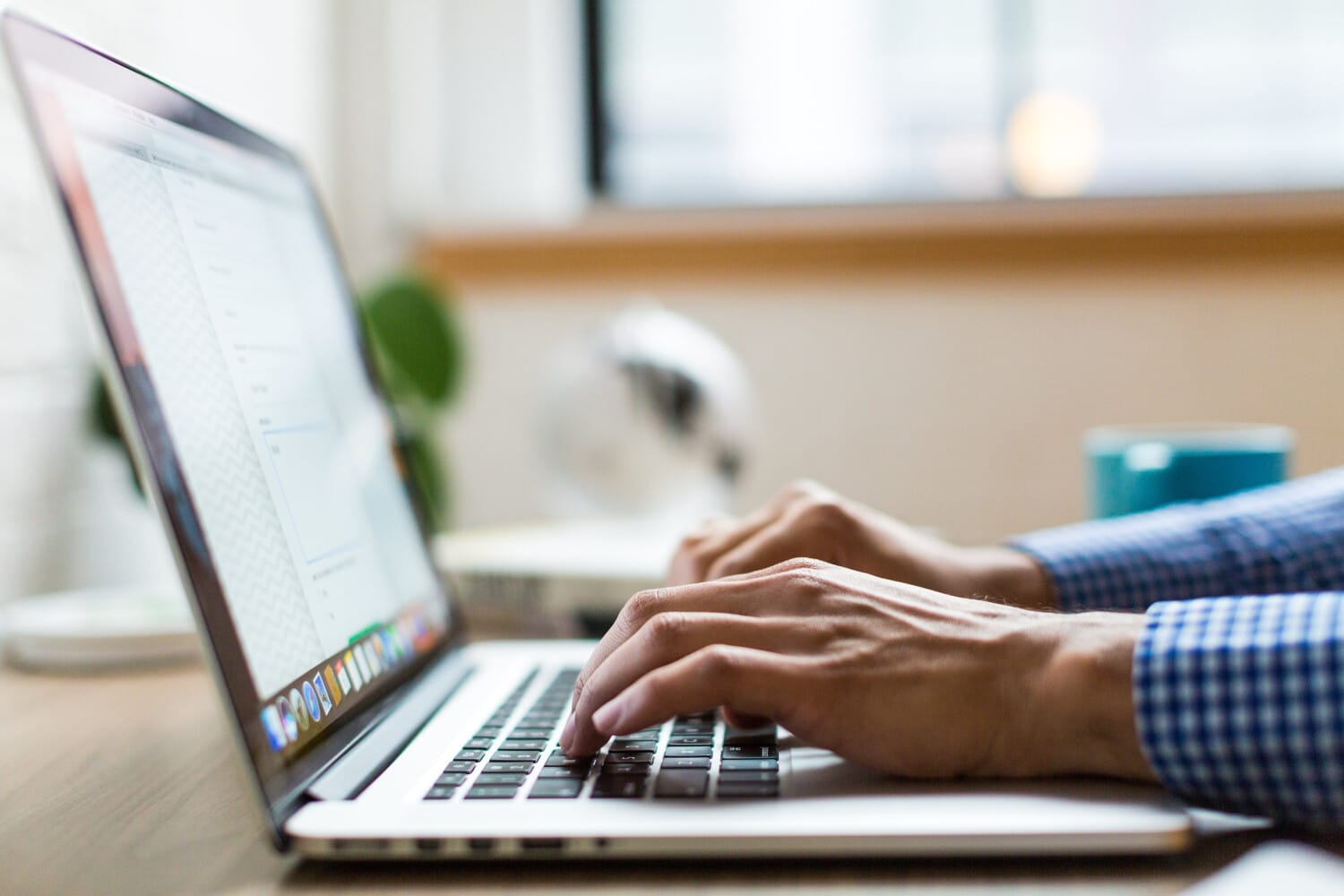 Care provider updating client schedules on a laptop with ShiftCare management software