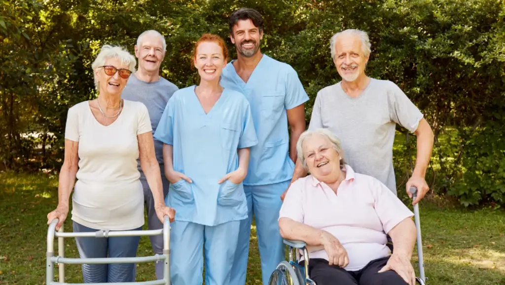 Elderly clients and caregivers together outdoors showing supportive home care environment