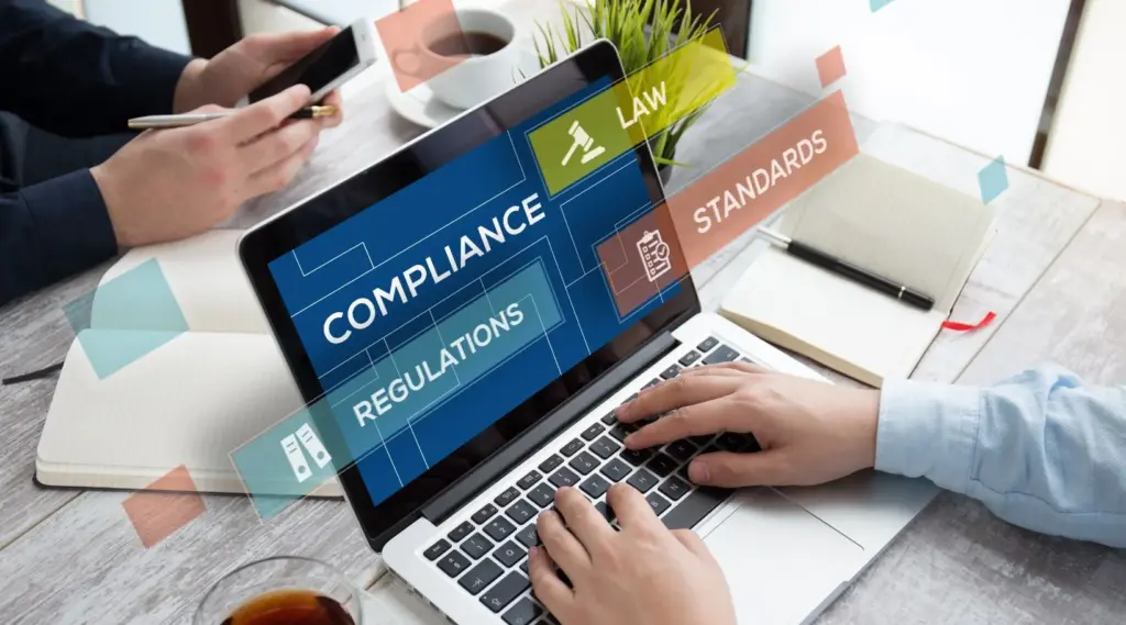 Person reviewing compliance, regulations, and standards on a laptop using ShiftCare software.