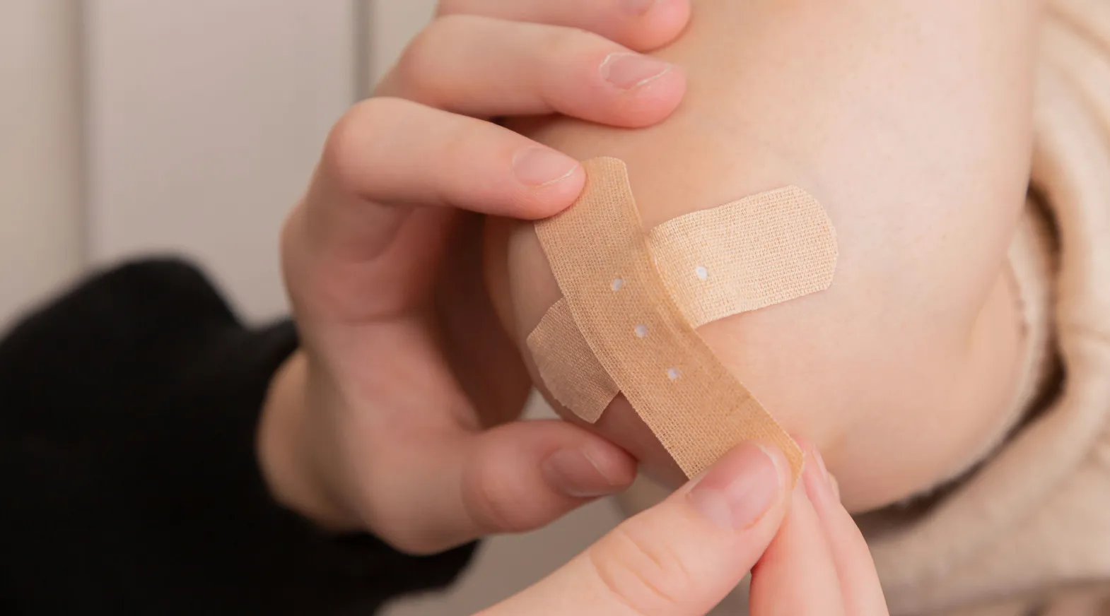 Applying bandage to elbow representing basic wound care during home care support.