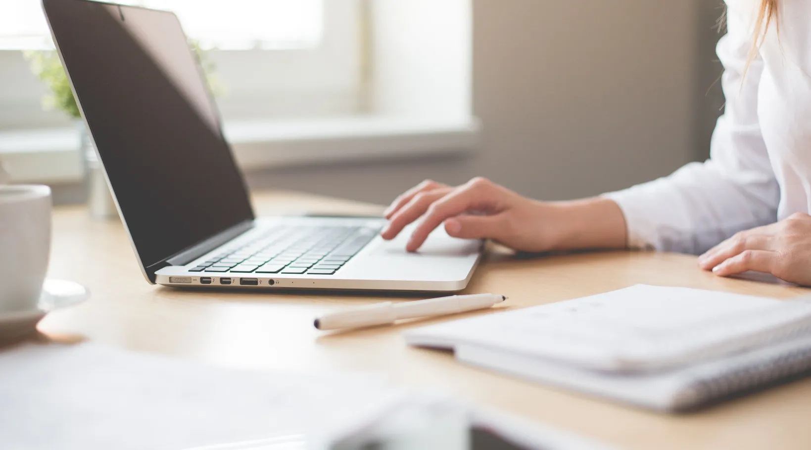 Home care administrator managing schedules and client records using ShiftCare home care software on a laptop.