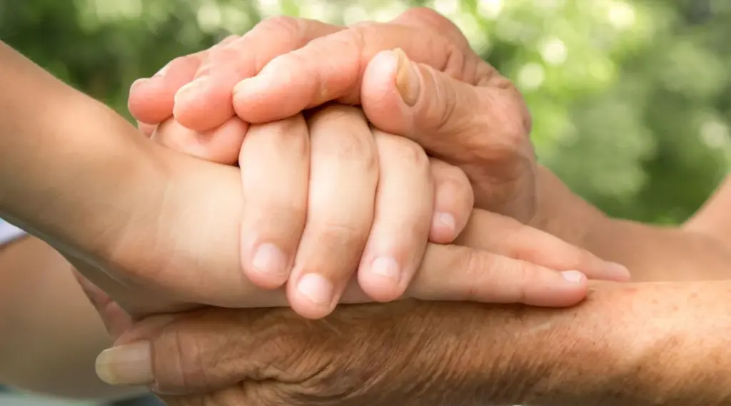 Supportive hands showing trust and care between caregiver and client with ShiftCare.