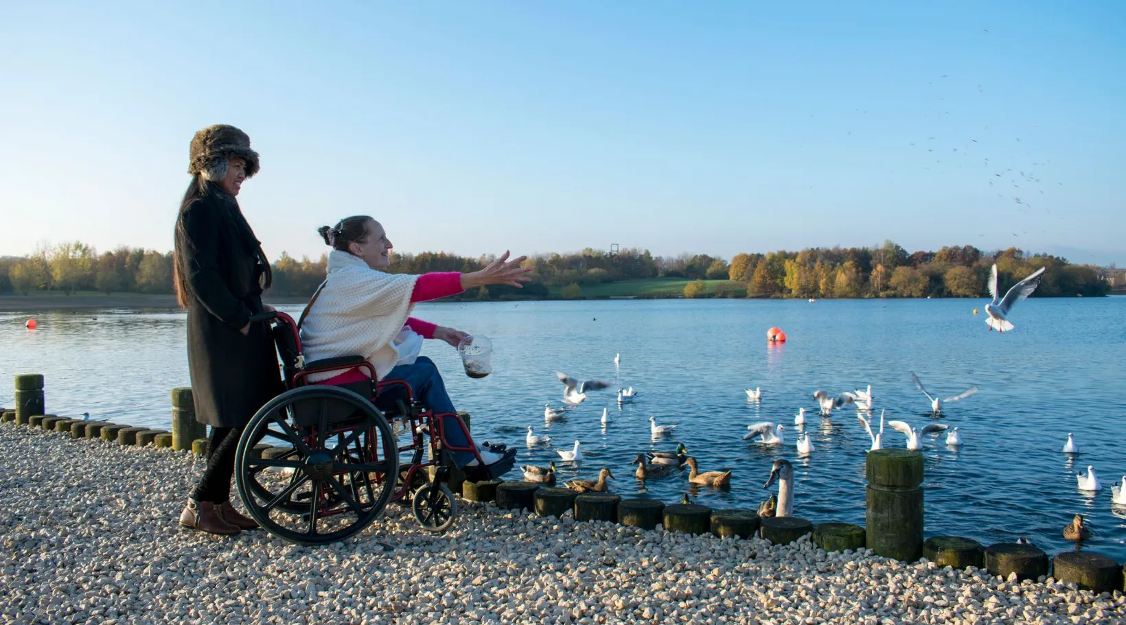 Support worker guiding person with disability outside, ShiftCare.