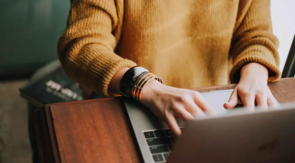 Hands using ShiftCare claim management software for home care agencies.