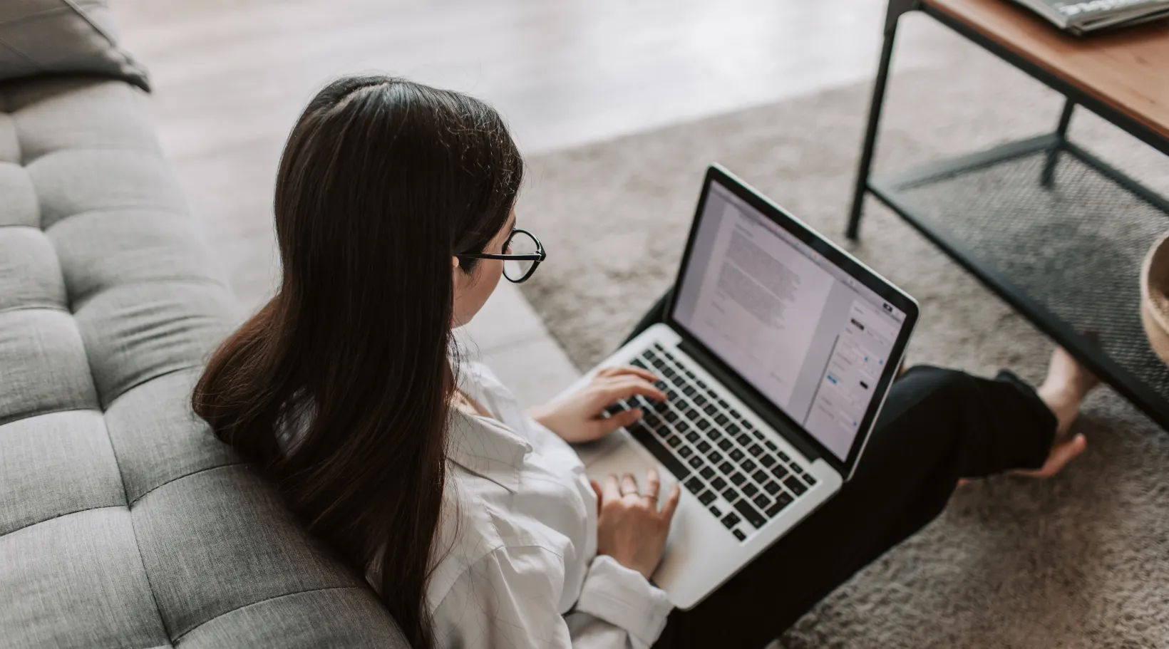 Professional focused on writing tasks in comfortable home workspace, ShiftCare.