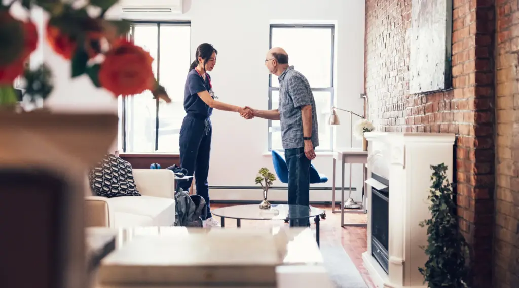 Care provider greeting elderly client at home, symbolizing trust and support with ShiftCare.