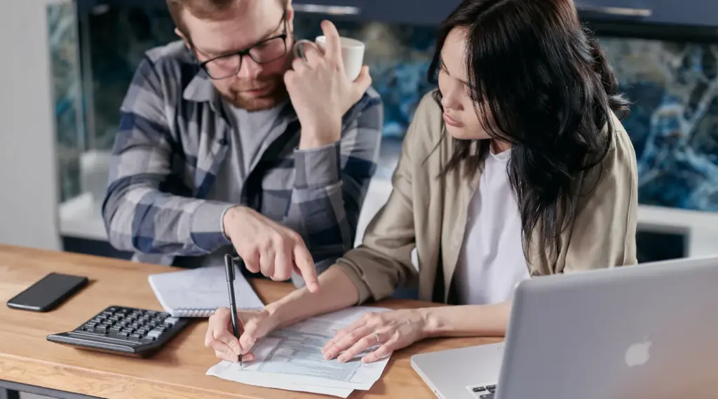 Financial review meeting with man and woman at desk, ShiftCare.