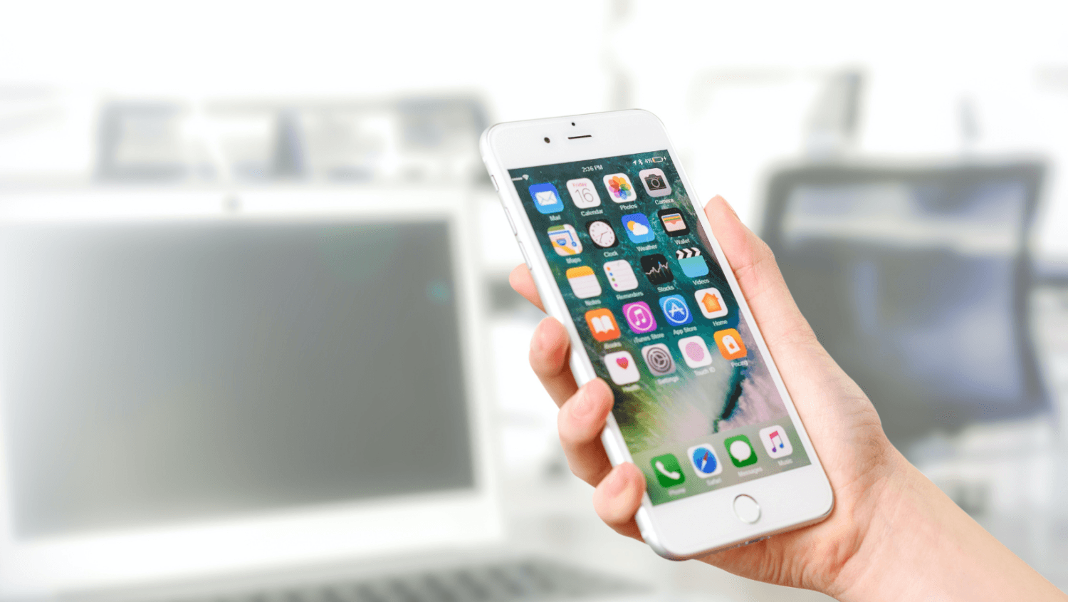 Hand holding iPhone, preparing to open the ShiftCare app for care management tasks.