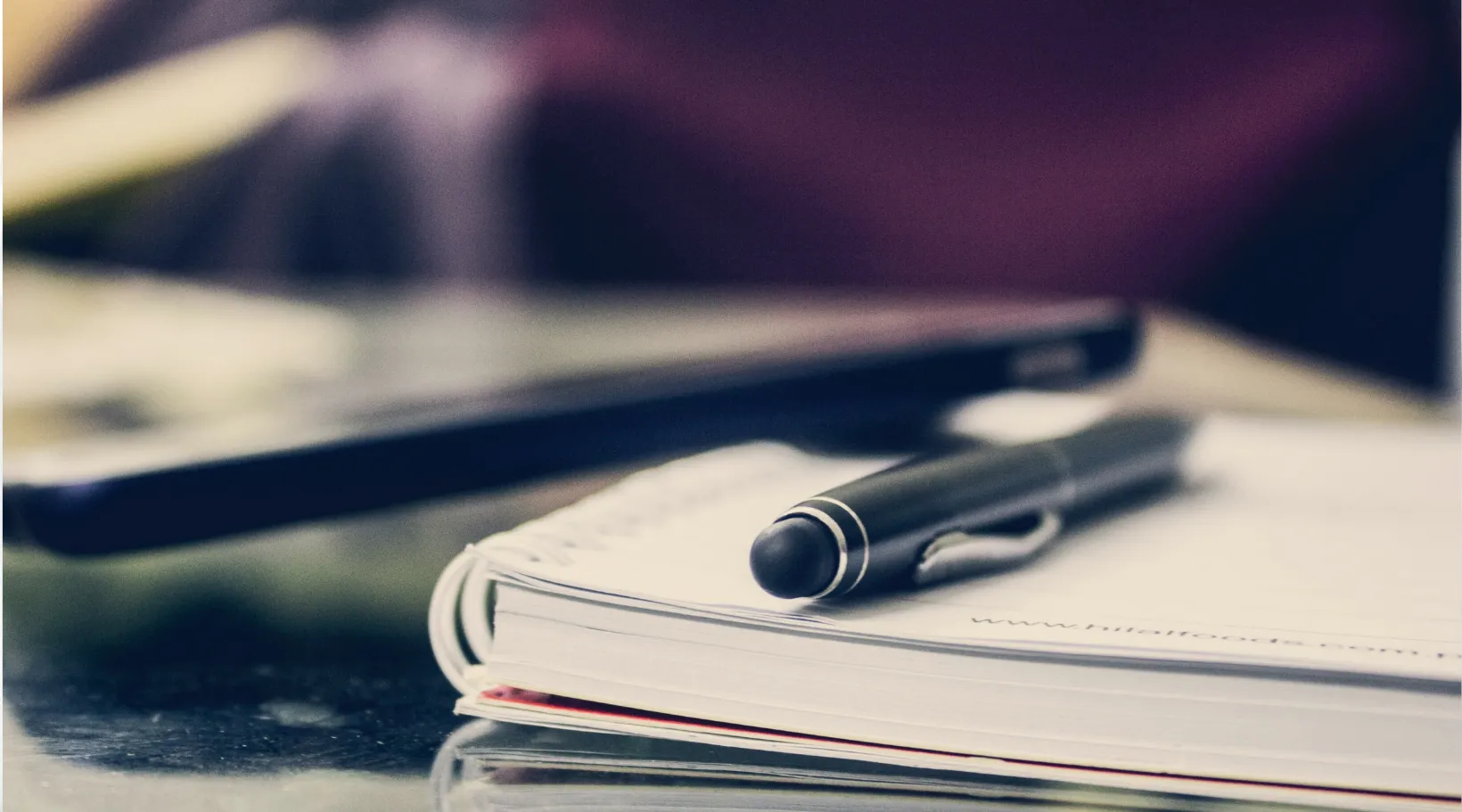 Pen and notebook on desk for NDIS care documentation, ShiftCare.