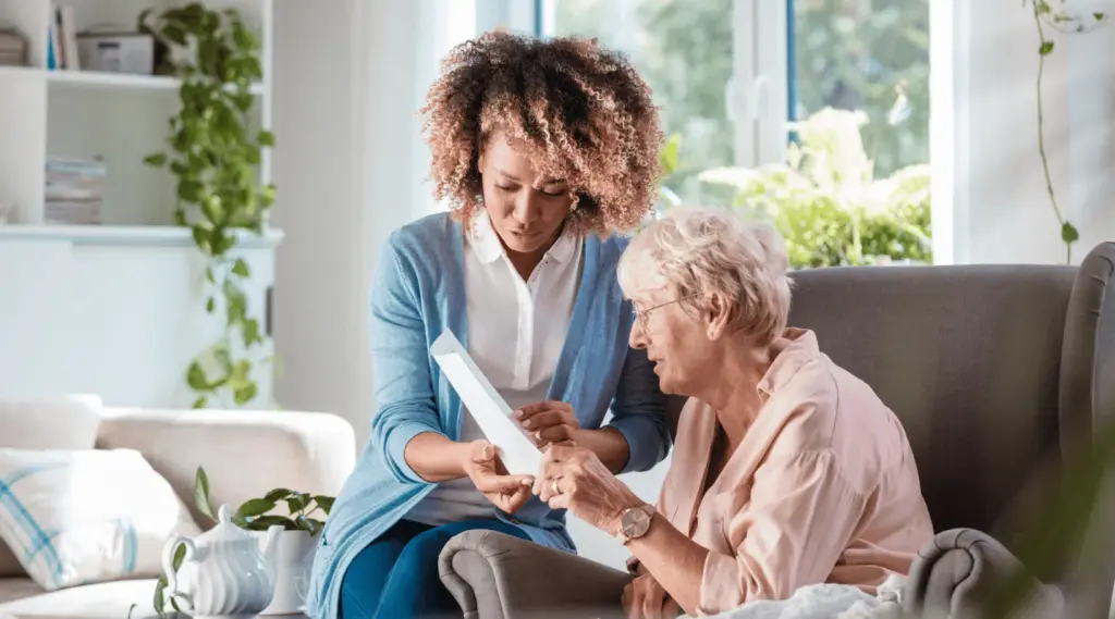 ShiftCare caregiver guiding senior through home care documents.