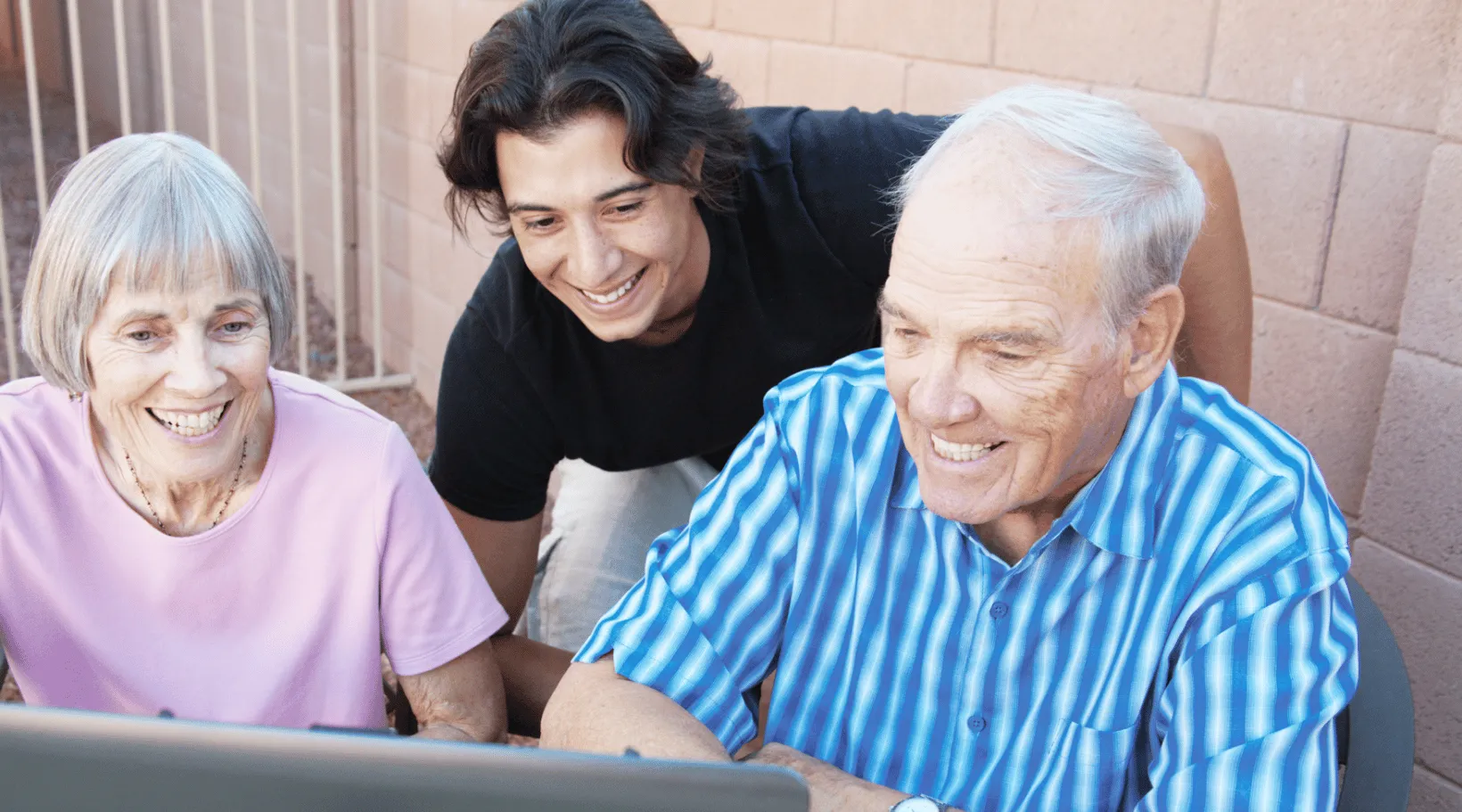 Caregiver assisting older adults with digital tools through ShiftCare home care software.