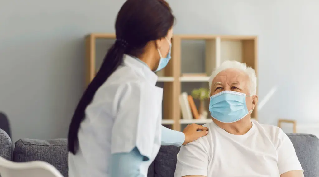Home caregiver supporting senior client with safety precautions, reflecting services coordinated with ShiftCare.
