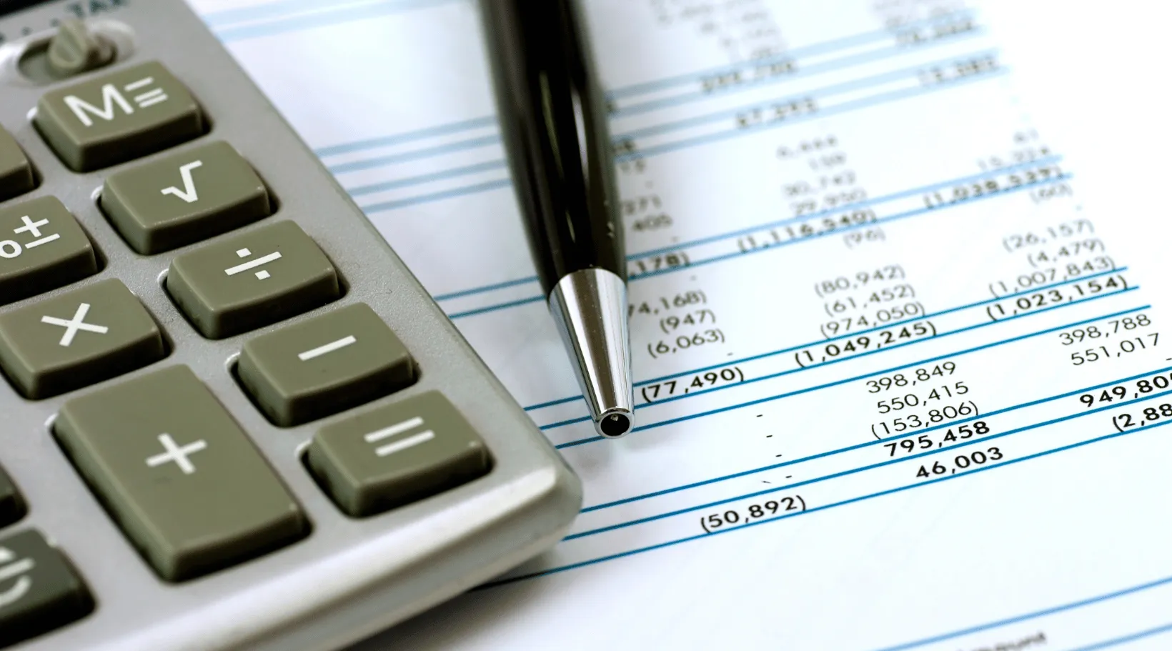 Accounting tools with calculator and balance sheet showing financial data in ShiftCare.