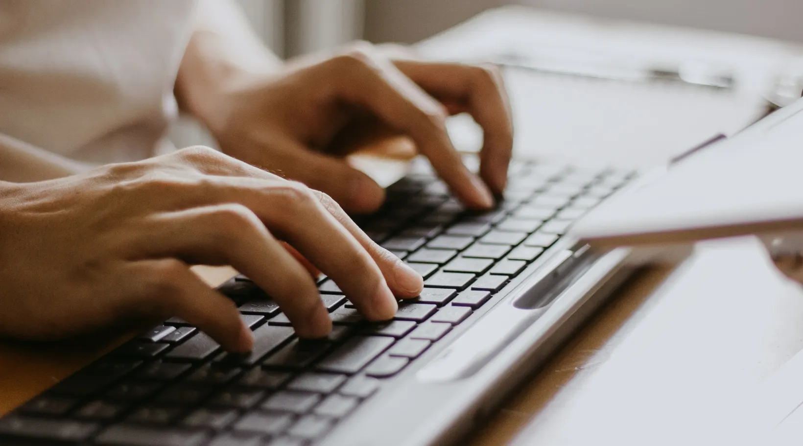 Professional using computer for digital documentation or reporting, ShiftCare.