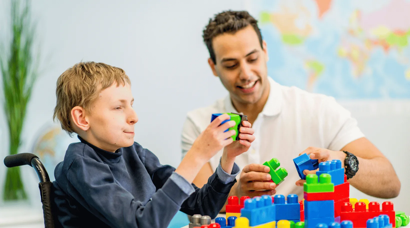 Support worker helping child with disability build blocks during therapy with ShiftCare.