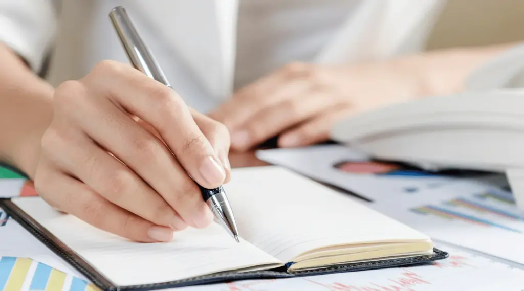 Care coordinator writing notes and documenting client care records using workflows supported by ShiftCare.