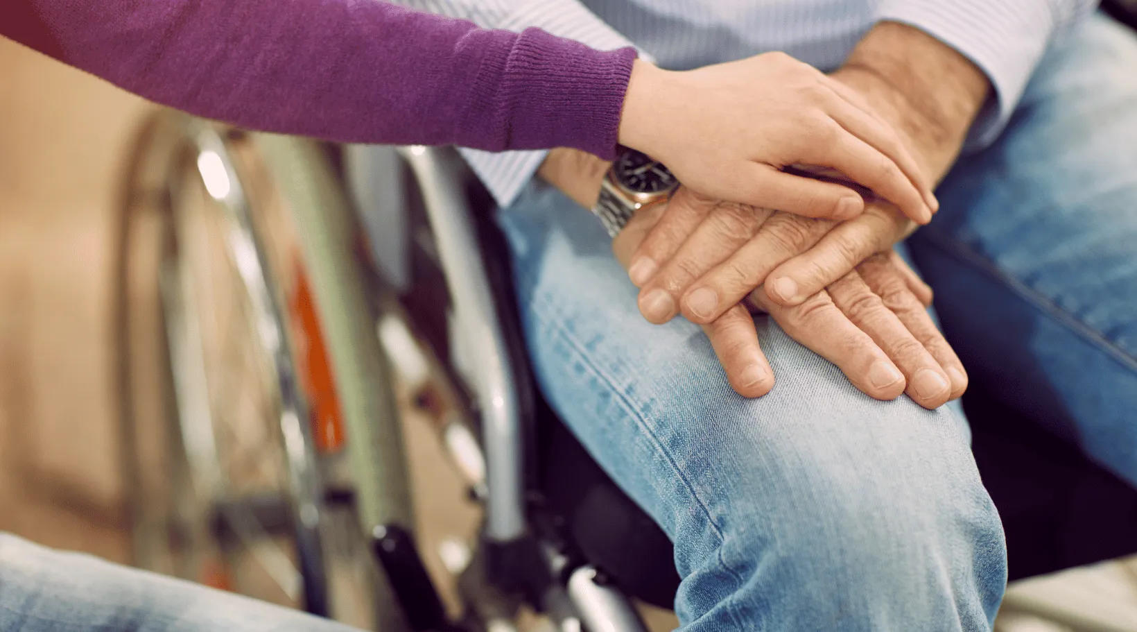 NDIS support worker reassuring a client in a wheelchair, representing compassionate care by ShiftCare.
