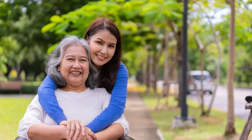Caregiver supporting senior woman in park symbolizing compassionate home care support.