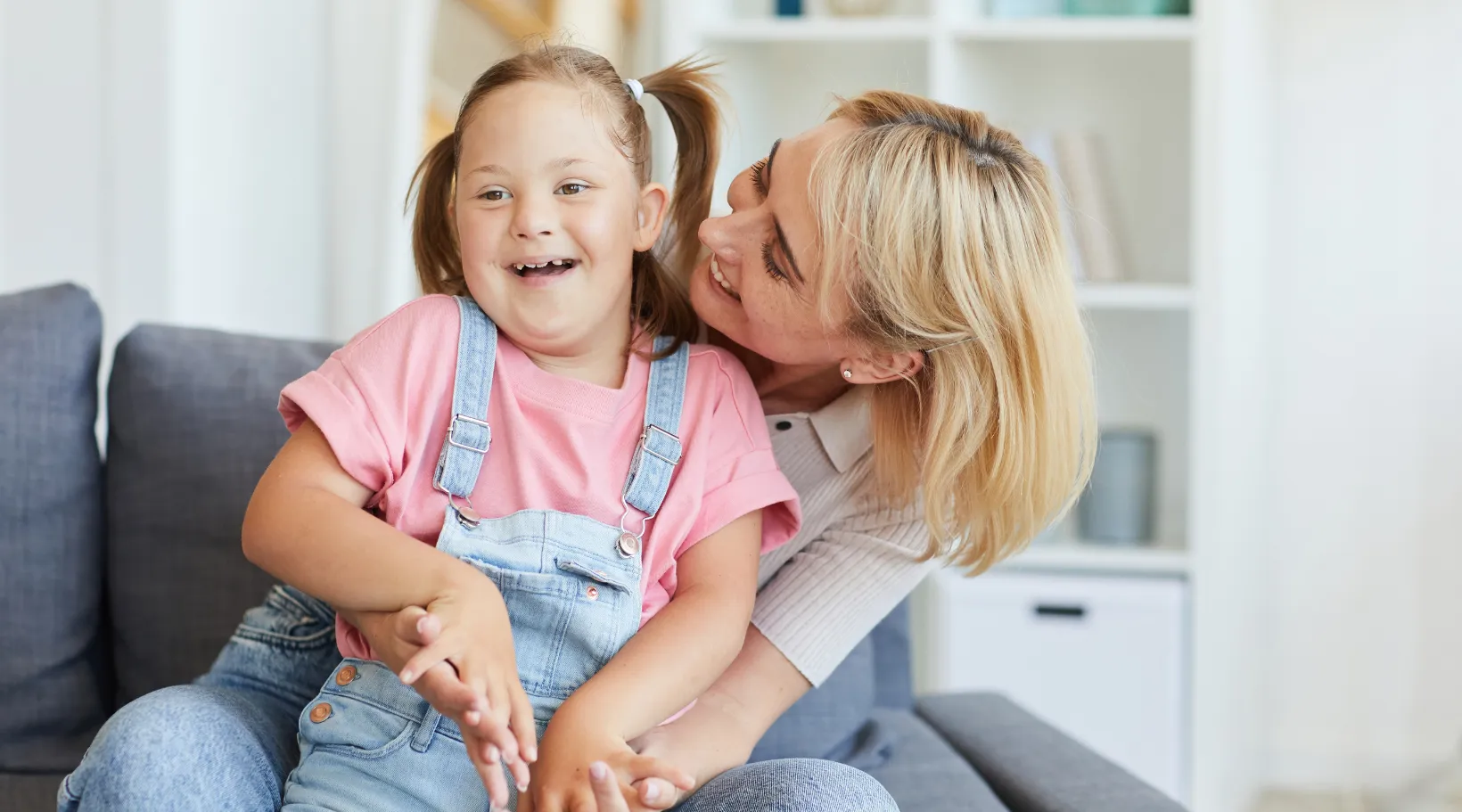 Happy child with Down syndrome playing with support worker, ShiftCare.