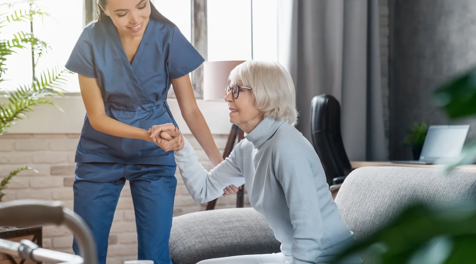 Carer assisting older woman with mobility during in-home care service, ShiftCare.