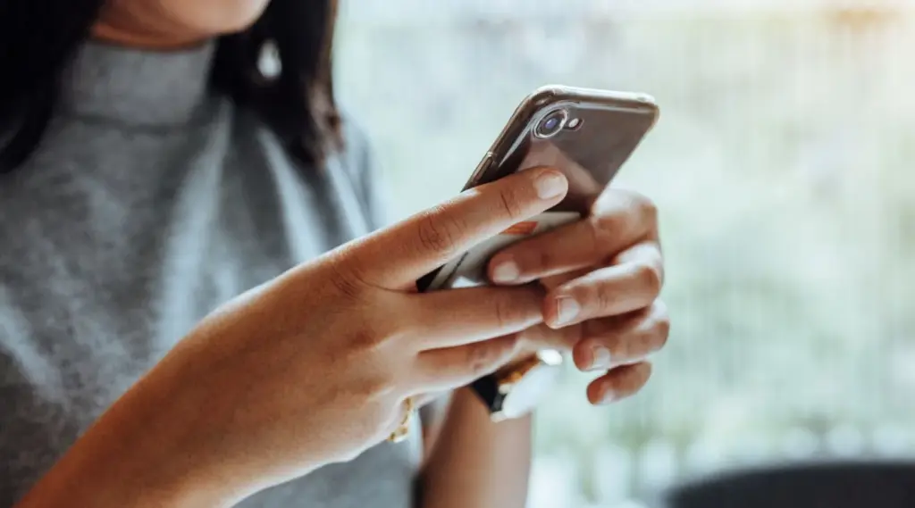Care worker using ShiftCare mobile app to manage schedules and client updates.