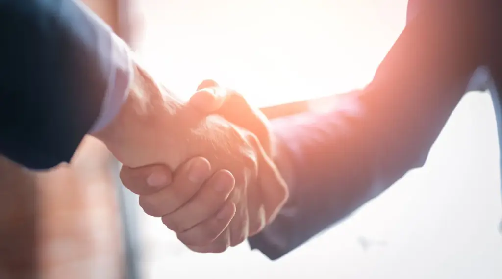 ShiftCare business partners shaking hands to seal a successful NDIS support services collaboration in Australia