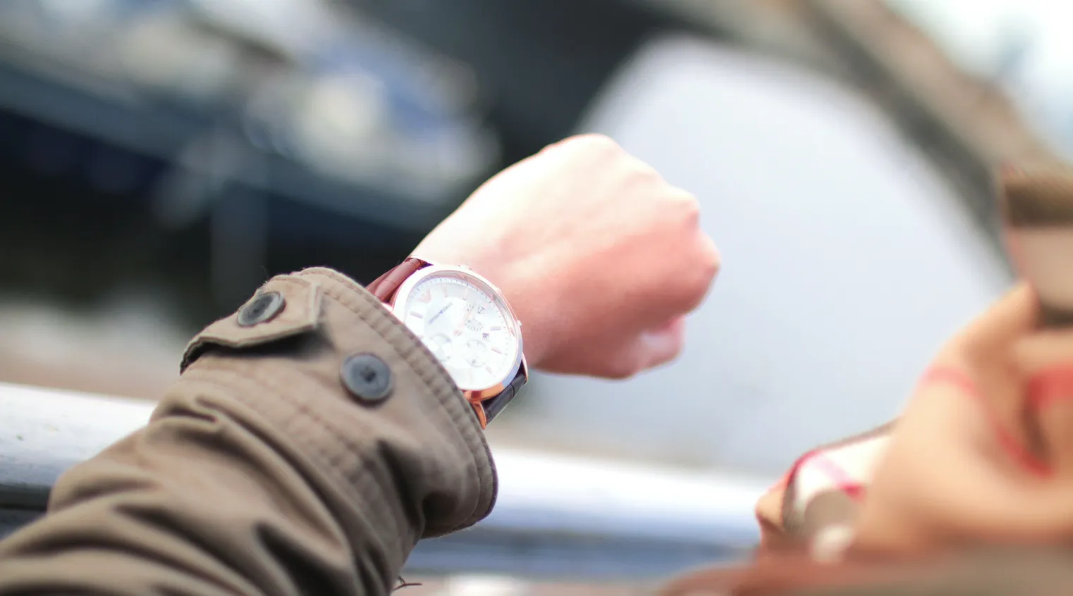 Person checking their wristwatch to manage NDIS appointment schedules and cancellations.