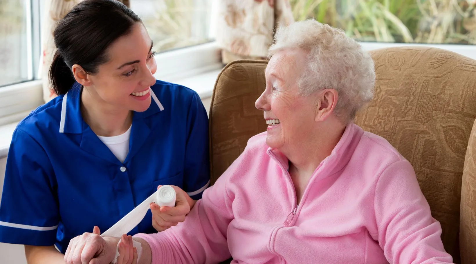ShiftCare nurse providing gentle aged-care support to senior woman.