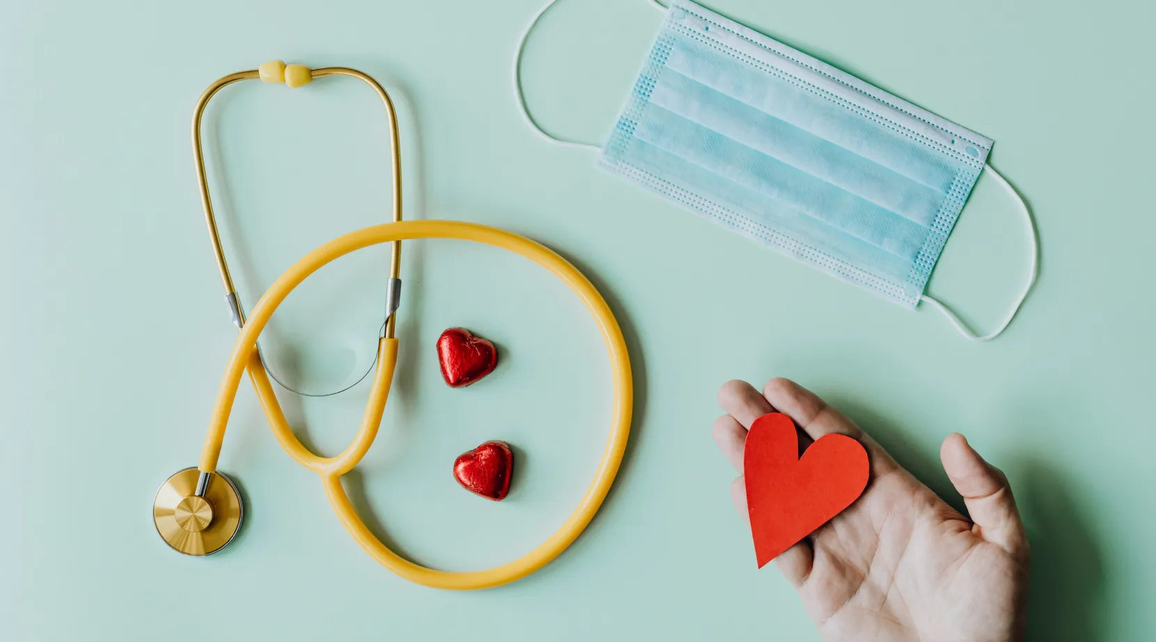 Stethoscope, mask, and red heart shapes symbolizing health and compassion, ShiftCare.