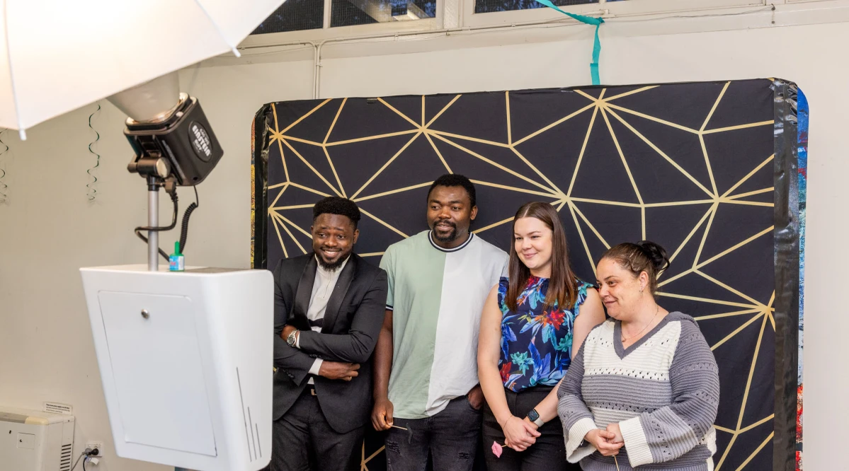Team members enjoying a lighthearted moment at a work party photo booth.