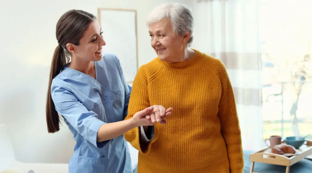 Support worker using ShiftCare to assist an older adult with daily home care activities.