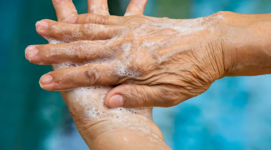 Caregiver practicing hand hygiene before a home visit, reflecting quality care supported by ShiftCare.