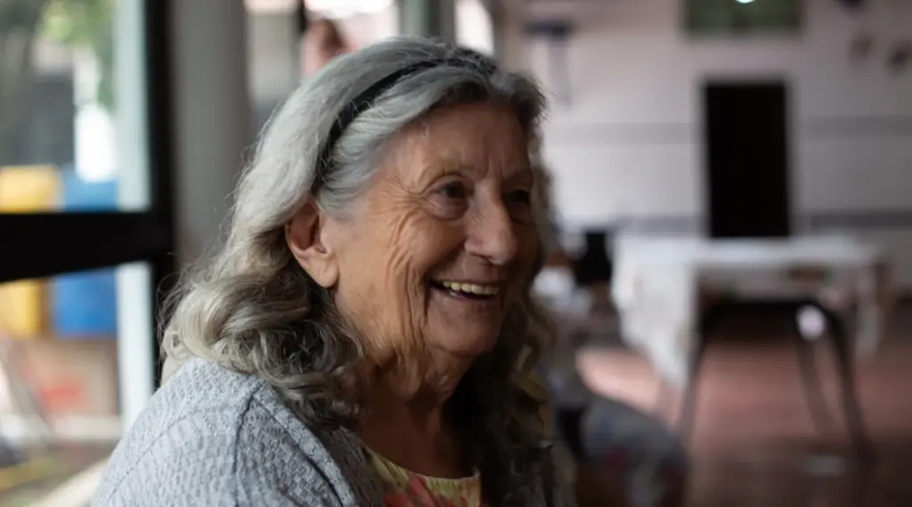 Elderly woman smiling warmly during a ShiftCare-supported home care visit session.