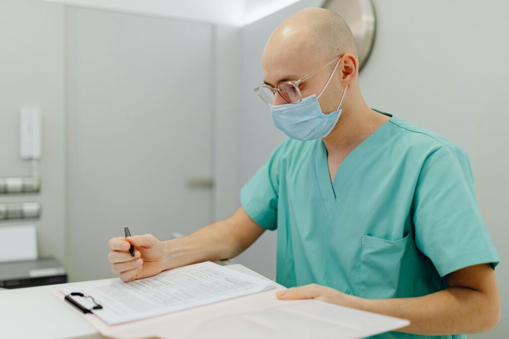 Healthcare professional writing down notes in his records