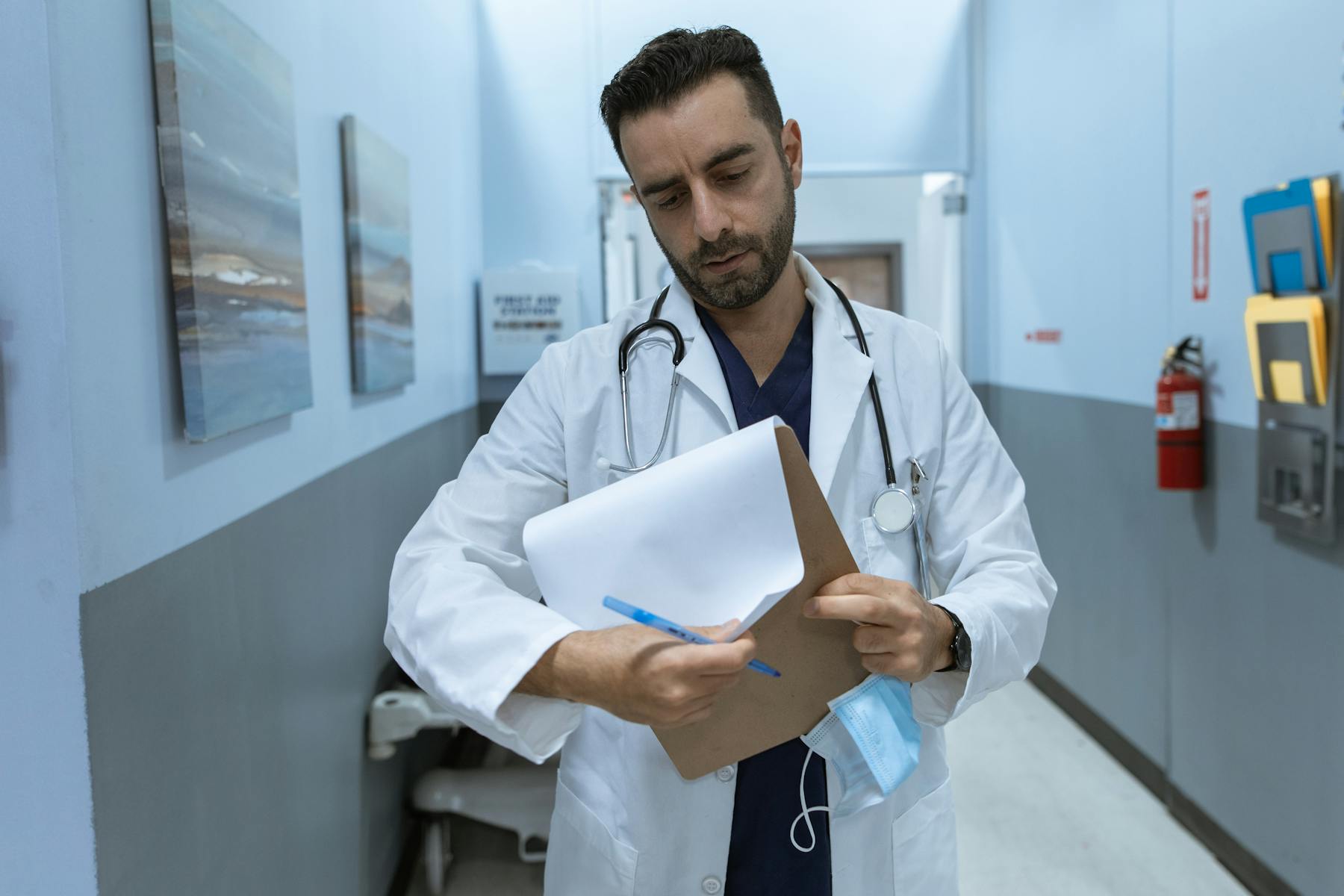 A doctor in a white lab coat looking at medical records