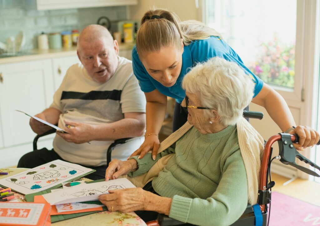 Caregiver attending to two seniors in a wheelchair