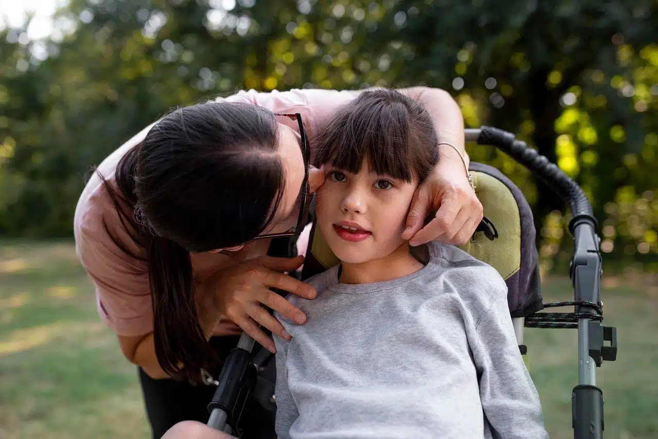 A female caregiver attending to a small child in a wheelchair