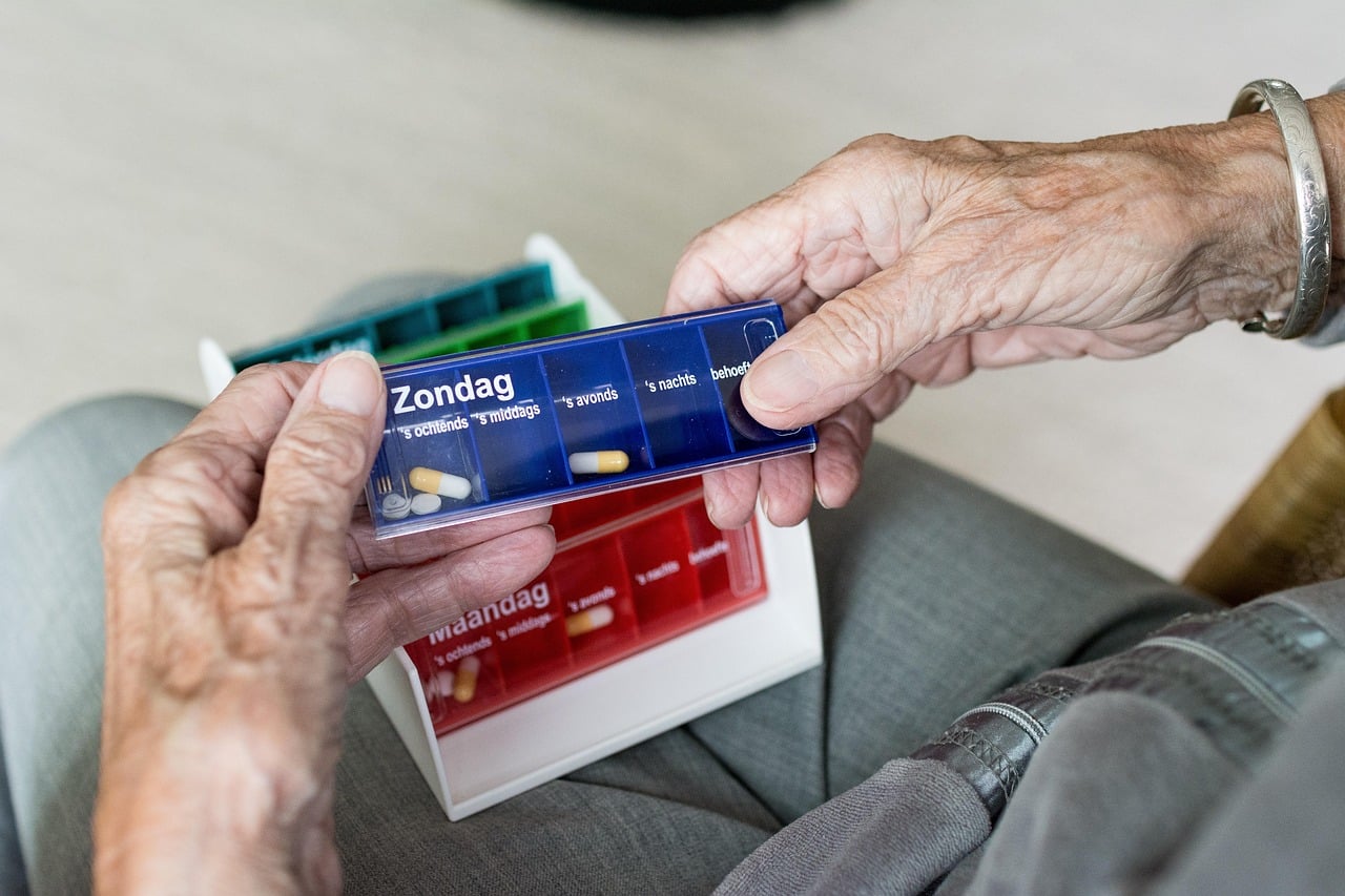 Older adult's hands holding a case of medicine