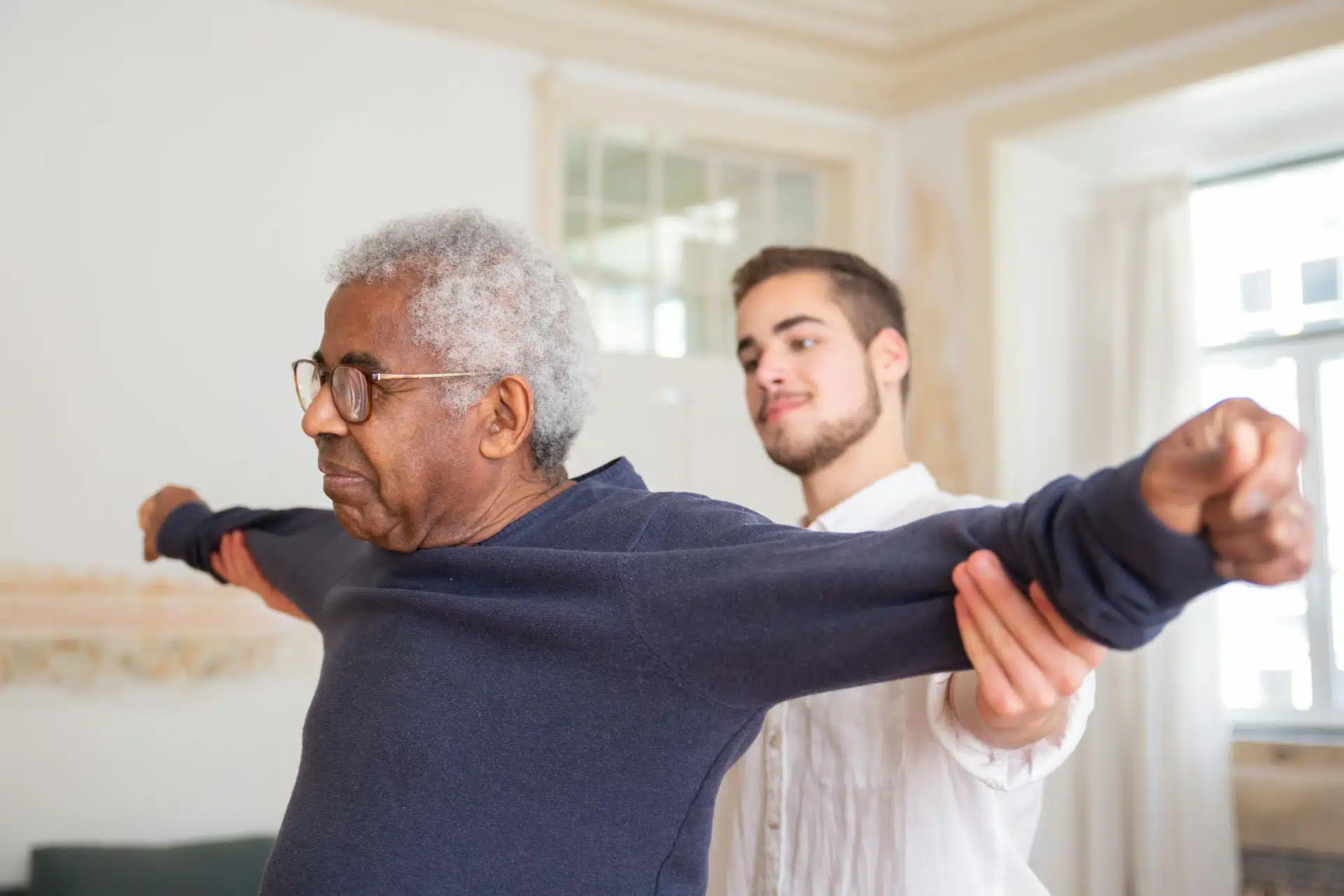 Caregiver helping older patient stretch